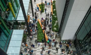 An interior view of The Spheres at an Amazon office, showing employees working amidst lush, tropical plants and a multi-level treehouse structure.
